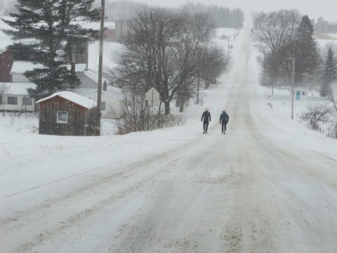 Two amish men walking on snow-covered roads