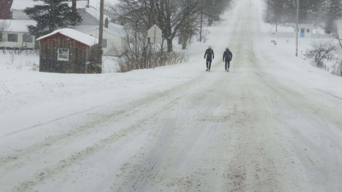 Two amish men walking on snow-covered roads