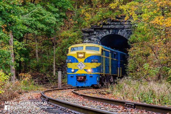 NYLE Railroad train exiting a tunnel on a fall day