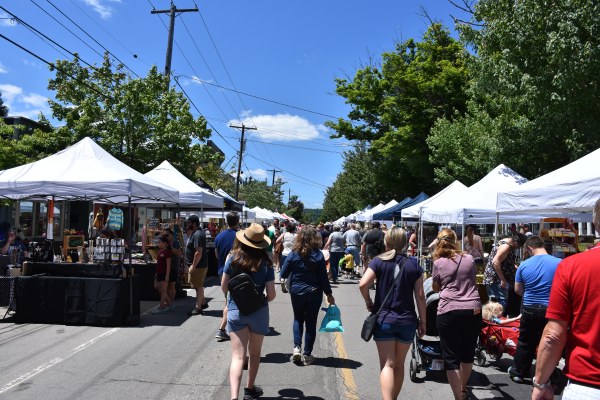 People strolling Main Street lined with Vendors for Arts and Crafts event